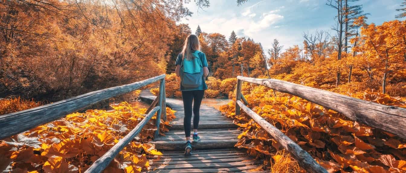 ragazza passeggia nel bosco durante foliage autunnale