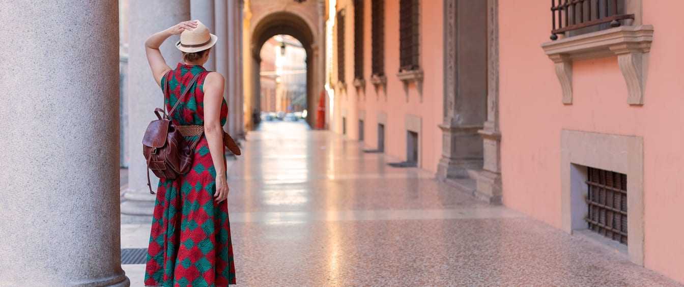Ragazza passeggia sotto i portici di Bologna