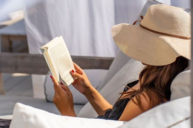 Girl reading a book poolside at UNA Hotels Forte Dei Marmi