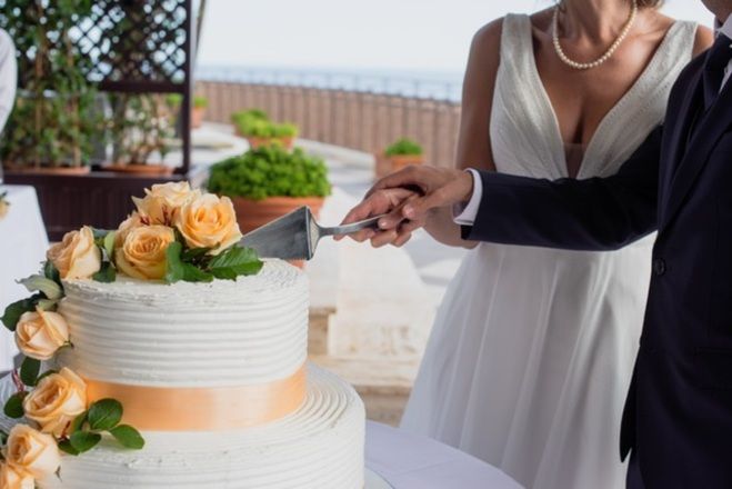 Taglio della torta durante un matrimonio sul mare